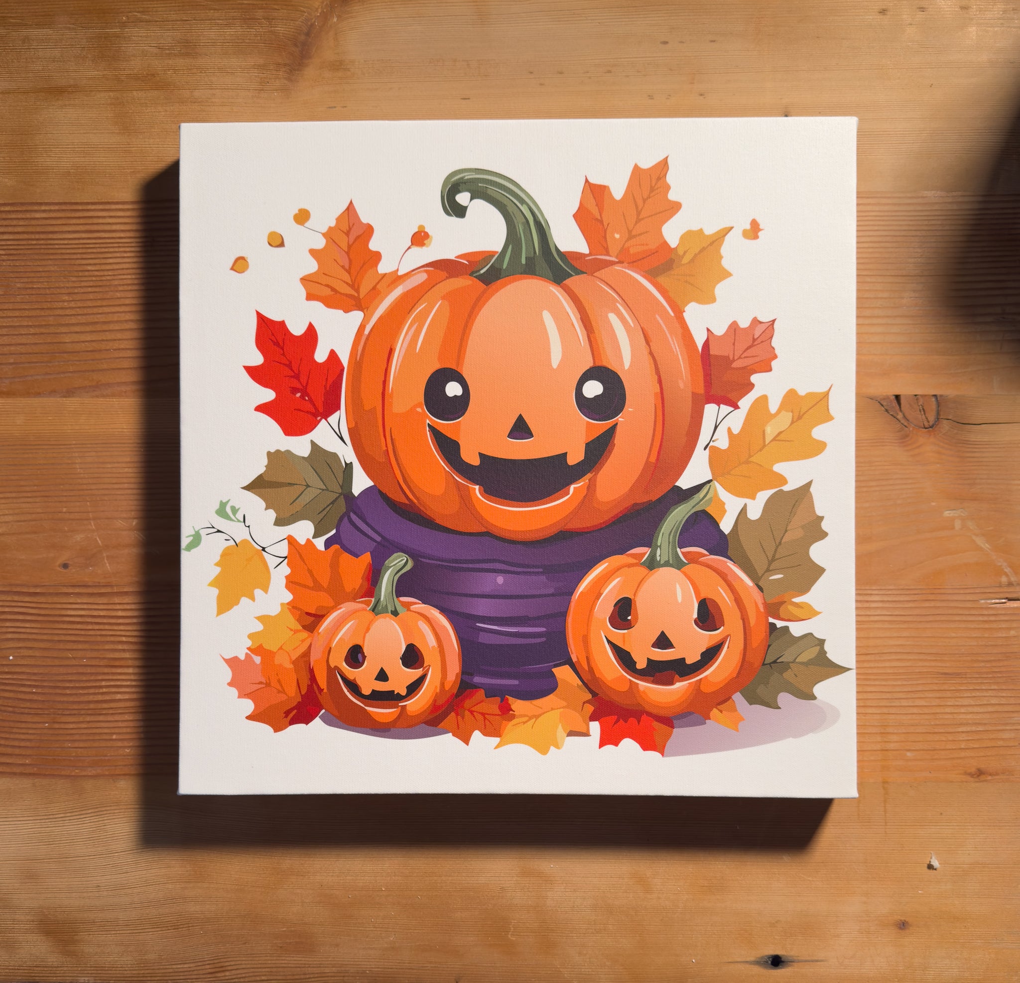 Trio of cheerful jack-o’-lanterns and fall leaves on a 16x16 Halloween canvas print, adding a playful touch to festive decor.